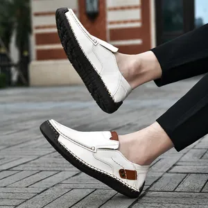 Detail of white leather slip-on loafers showing hand-stitched seams and rubber sole details