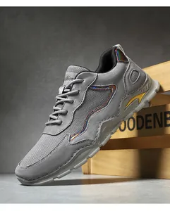 Detail of grey leather hiking shoes featuring reflective strips and chunky durable soles
