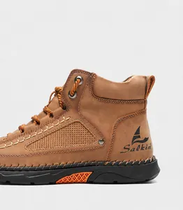 Detail of handcrafted stitching and side perforations on khaki brown PU leather boots