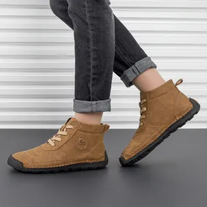 Detail of brown leather work boots with white contrast stitching and durable rubber sole