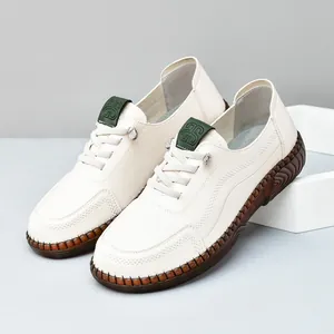 Off-white leather casual sneakers with thick brown rubber sole and hand-stitched detail