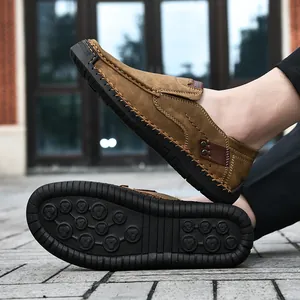 Macro detail of men's khaki loafers showing hand-stitched seams and non-slip rubber sole