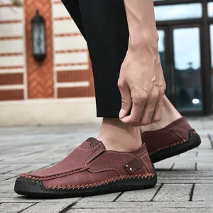 Detail of reddish-brown leather loafers featuring contrast stitching and casual slip-on style