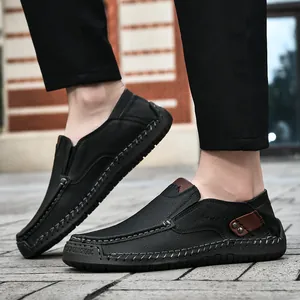 Close-up of black leather loafers with hand-stitched details and rubber sole stamp