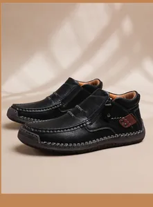 Detalle de bota de cuero negro con cremallera lateral y adornos de cuero marrón