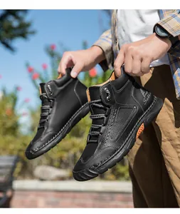Detail of men's black PU leather high-top boot with orange accents and anti-slip rubber sole