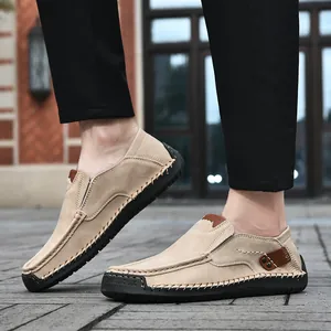 Macro shot of khaki suede slip-on loafers featuring hand-stitched details and rubber soles