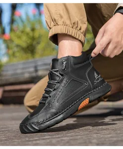 Detail of black leather ankle boot showing Salkin logo and orange non-slip sole accent