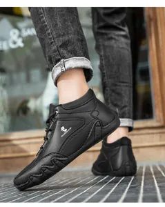 Détail de bottines décontractées en cuir noir avec logo renard et texture cousue