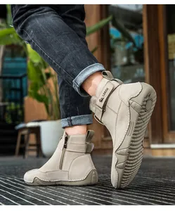 Dettaglio di stivali in pelle kaki con cerniera laterale e suola in gomma resistente