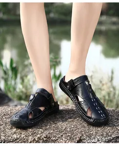 Detalle de sandalias de cuero negro para exterior con costuras y suela de goma robusta