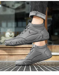Détail de bottines en cuir gris avec surpiqûres blanches et semelles en caoutchouc