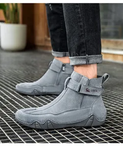 Dettaglio di stivali grigi in pelle con cerniera laterale e cinturino decorativo