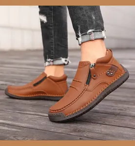 Detalle de botas de cuero marrón con cremallera, remaches y costuras hechas a mano para hombre
