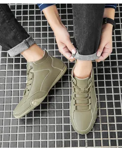 Détail de bottes en cuir vert armée avec coutures contrastées et design montant lacé