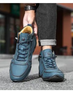 Détail de bottines en daim bleu avec doublure jaune et logo bélier en relief sur languette