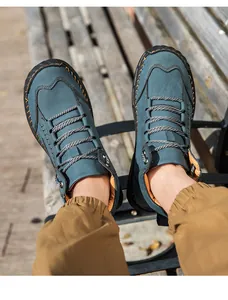 Detail of dark blue PU leather boots with orange hand-stitching and non-slip rubber soles