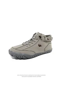 Detail of high-top grey suede boots showing non-slip rubber sole and velcro straps