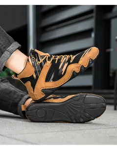 Detail view of brown and black men's high-top outdoor boots with wave-patterned non-slip sole