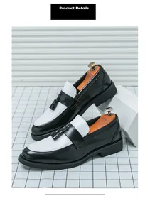 Détail de mocassins noirs et blancs avec glands sur fond professionnel blanc