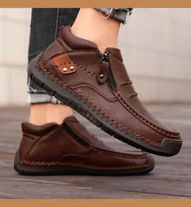 Detalle de costuras a mano y cremallera lateral en zapatos altos de cuero marrón para hombre