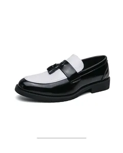 Détail de mocassins à gland noir et blanc en cuir verni avec semelle épaisse en caoutchouc