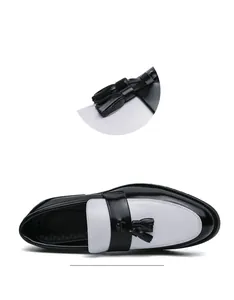 Détail de mocassins à pampilles noir et blanc montrant la texture du cuir et les coutures