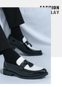 Détail d'un mocassin en cuir noir et blanc avec glands classiques et semelle en caoutchouc