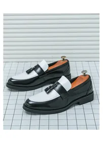 Détail de mocassins noirs et blancs avec glands élégants et une semelle épaisse en caoutchouc