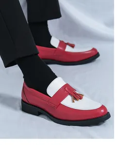 Vue détaillée des mocassins bicolores rouge et blanc avec pompons et semelle en gomme