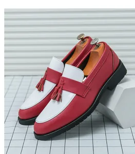 Détail de mocassins en cuir bicolore rouge et blanc avec pompons élégants pour hommes