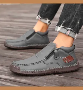 Detalle de bota de cuero gris con cremallera lateral y costuras hechas a mano