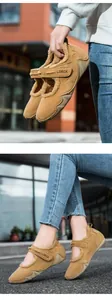 Detalle del forro de piel cálida y el cierre de velcro en los zapatos de invierno camel