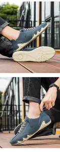 Close-up of grey-blue suede casual shoes with wavy rubber soles and detailed contrast stitching