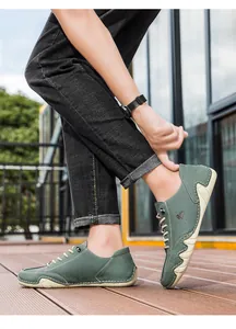 Detail of dark green suede casual shoe showing white hand-stitching and rubber sole