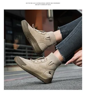 Dettaglio di stivali alti in pelle scamosciata beige con collo in maglia e logo animale