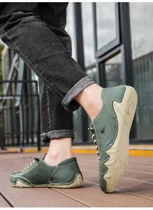 Detail of dark green suede casual shoes with white stitching and wavy rubber soles