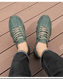Top view of men's dark green suede low-top casual shoes on a wooden walkway
