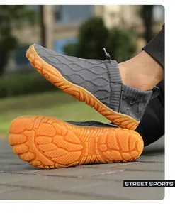Detail of grey breathable knit fabric and anti-slip orange rubber sole for outdoor water shoes