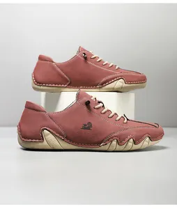 Detail of red suede leather casual shoes with white stitching and textured rubber sole
