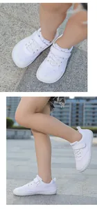 Detail view of white kids barefoot sneakers with mesh upper and flat rubber soles