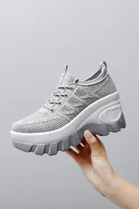 Detail showing grey breathable mesh texture and thick wedge sole with heart embossed pattern