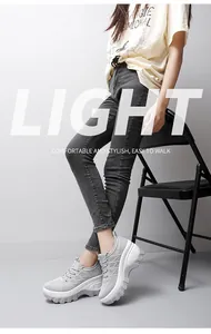 Detailed side view of grey platform mesh sneakers with thick white soles on a female model