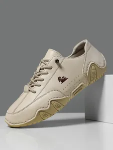 Vista detallada de zapato casual de cuero beige con logo de carnero y suela de goma ondulada