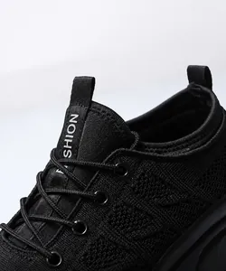 Detail view of breathable black mesh knit upper and stylish branded ribbon on casual sneaker