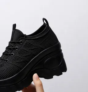 Detail view of 8cm platform heel and breathable mesh material on black casual sneakers