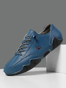 Detalle de los zapatos casuales de cuero azul oscuro con logo marrón y suela de goma robusta