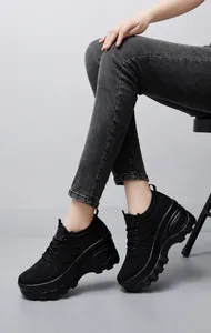 Side view of model wearing black breathable mesh platform sneakers with non-slip thick sole