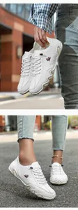 Nahaufnahme weißer Leder-Freizeitschuhe mit elastischen Schnürsenkeln und Gummisohle