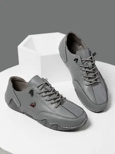 Detalle de zapatos casuales de cuero gris oscuro con cordones elásticos y patrones rojos